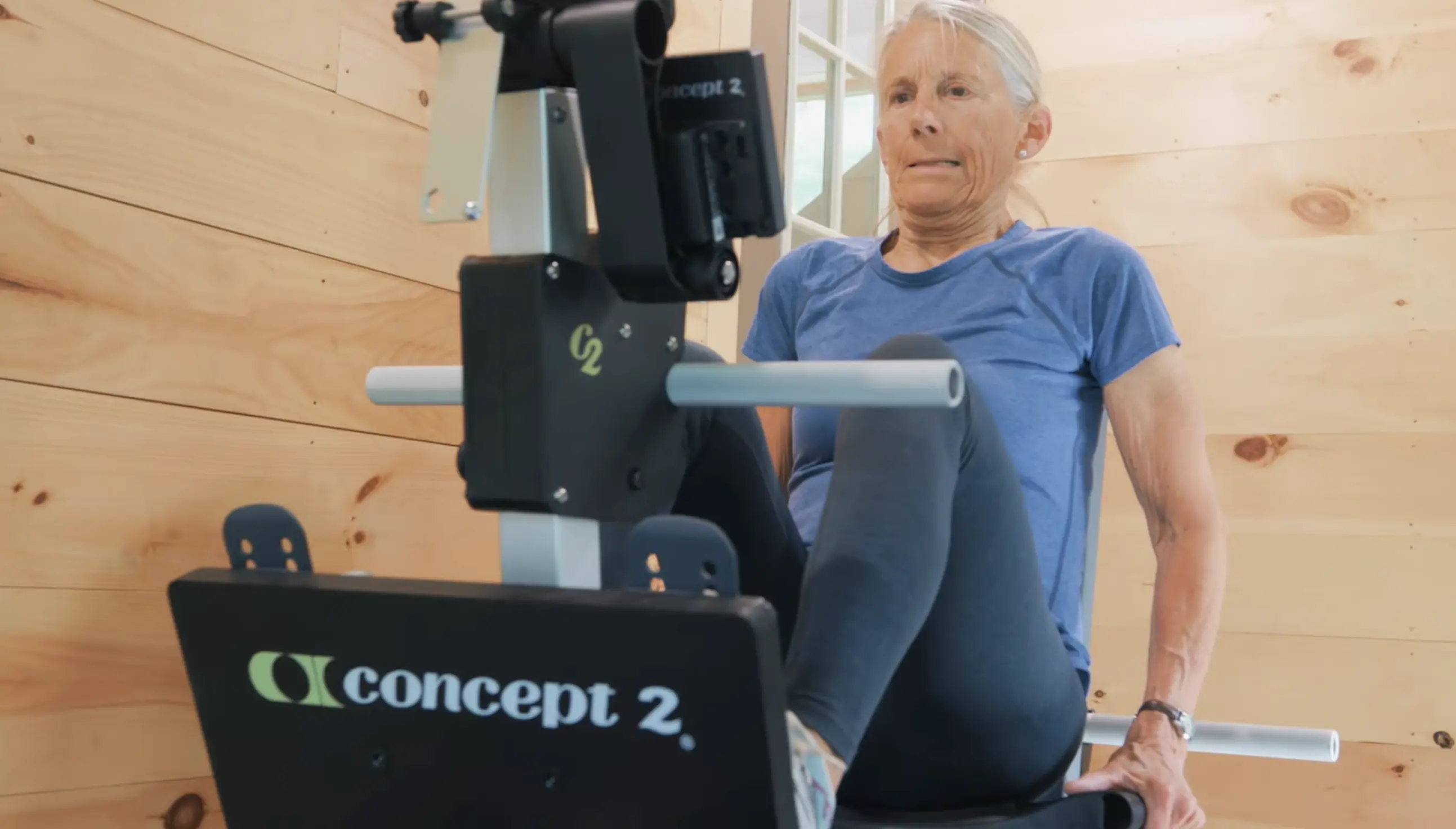 {"sl":"\u017denska v modri majici telovadi na vesla\u0161kem trena\u017eerju Concept2.","hr":"","en":""}